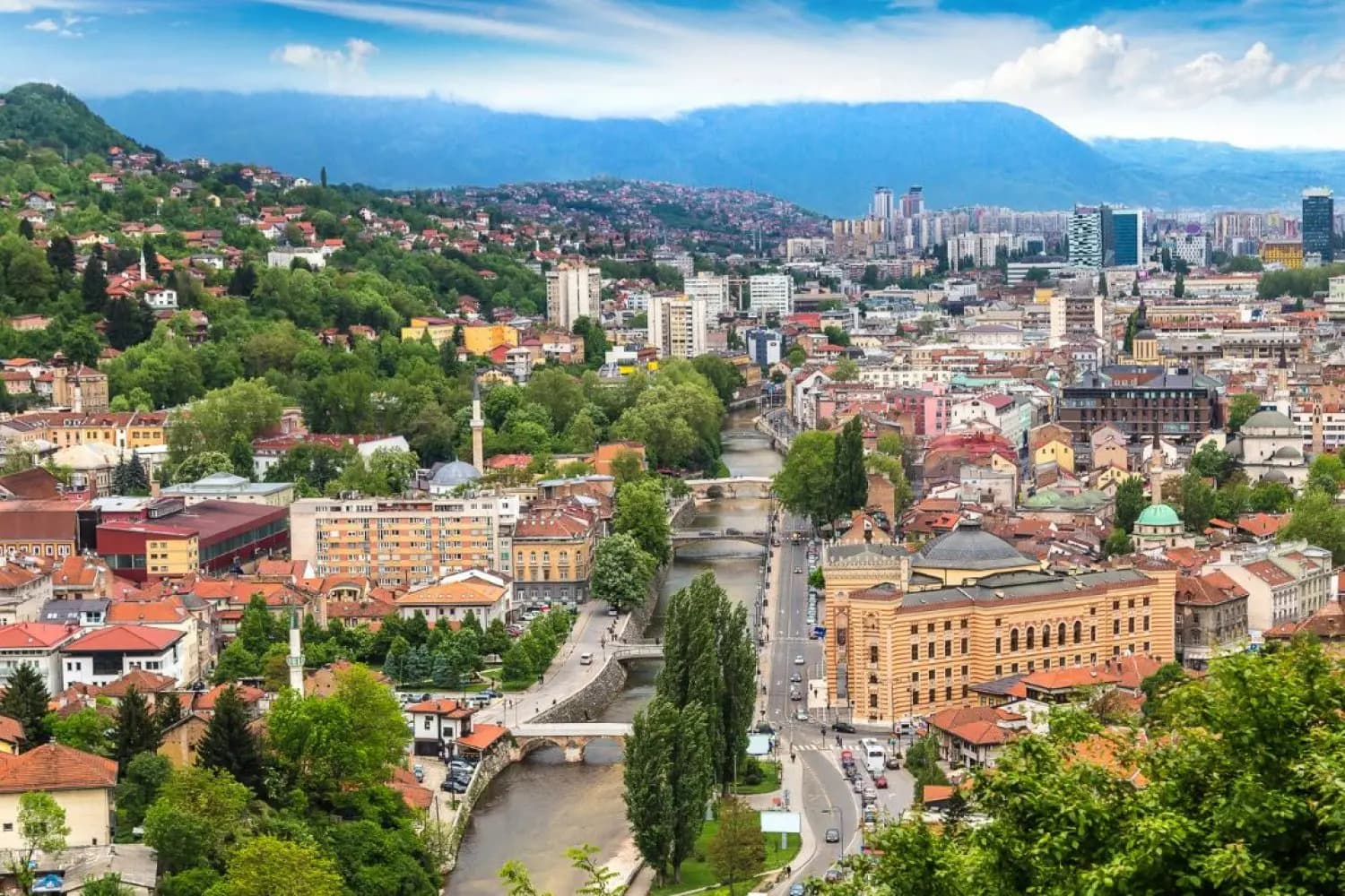 A view over old Sarajevo, its houses and minarets among green hills